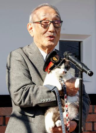 和歌山電鉄の小嶋光信社長に抱かれる貴志川線貴志駅３代目猫駅長に就任した猫の「よんたま」＝７日午前、和歌山県紀の川市