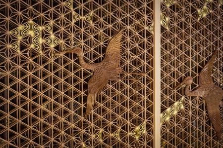 　八芳園メインロビー壁面を飾る福岡県大川市の組子細工。夫婦鶴の彫刻をあしらった（提供写真）