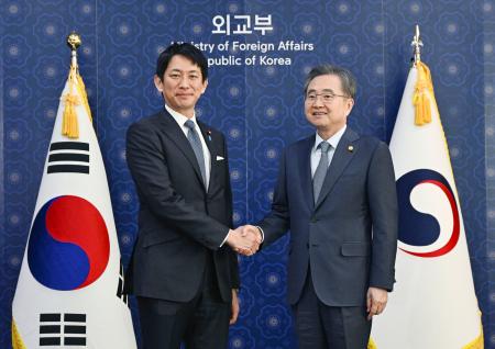 韓国の趙顕外相（右）と握手する自民党の小林政調会長＝８日、ソウル（共同）