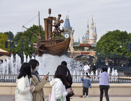 中国の上海ディズニーランドで記念撮影をする市民ら=2022年