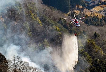 山梨県上野原市の扇山で続く消火活動＝１０日午前９時２５分（共同通信社ヘリから）