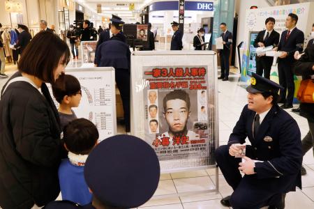 市内のショッピングモールで、小暮洋史容疑者についての情報提供を呼びかける群馬県警の警察官＝１２日午前、群馬県高崎市