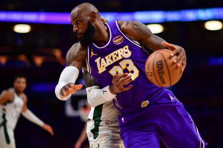 ９日のバックス戦で競り合うレーカーズのレブロン・ジェームズ＝ロサンゼルス（イマジンイメージズ・ロイター＝共同）