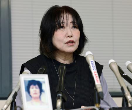 神戸市役所で記者会見する佐藤悦子さん。手前は母正子さんの写真＝１３日午後