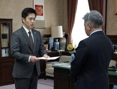 大阪府議会の金城克典議長（右）に辞職願を提出する吉村洋文知事＝１６日午前、大阪府庁