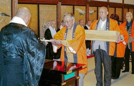 高野山の金剛峯寺に特大ゴボウ「はたごんぼ」を奉納する「くにぎ広場」の関係者ら＝１６日、和歌山県高野町