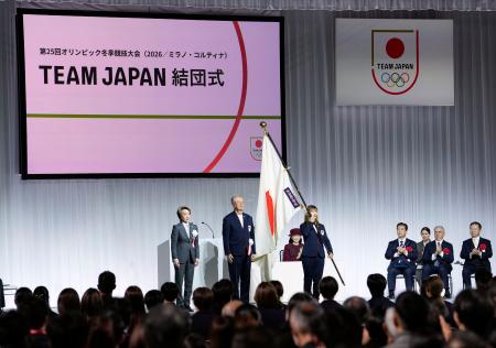 ２月６日に開幕するミラノ・コルティナ冬季五輪に向けて開かれた日本選手団の結団式。旗手代行を務めたフィギュアスケート女子の坂本花織に団旗が手渡された＝１８日午後、千葉県船橋市