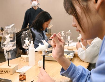 あめ細工体験。出来上がったウサギに絵を付ける=東京都台東区