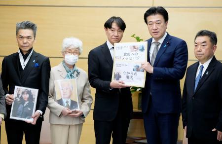 木原官房長官（右から２人目）に署名を手渡す「横田めぐみさんとの再会を誓う同級生の会」の池田正樹代表。左から２人目は横田早紀江さん＝１９日午後、首相官邸