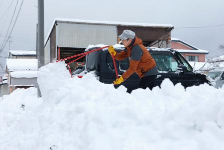 新潟県柏崎市で雪かきをする人＝２２日午前