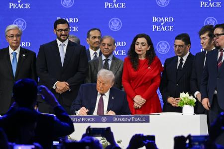 ２２日、スイス東部ダボスで「平和評議会」設立の署名をするトランプ米大統領（ゲッティ＝共同）