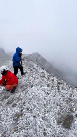 機体が見つかった熊本県・阿蘇山の中岳火口付近で活動する捜索隊＝２１日（熊本県警提供）