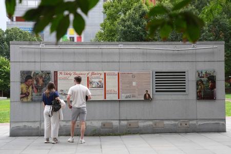 米東部フィラデルフィアの大統領公邸跡地にあった奴隷制の経緯を伝える展示物を見る人たち＝２０２５年８月（ＡＰ＝共同）