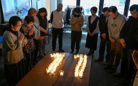 能登半島地震の発生時刻に合わせ黙とうする石川県からの広域避難者ら＝２４日午後４時１０分、大阪市中央区