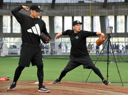巨人の主力選手の合同練習でブルペン入りし、則本（手前）と投げ込む田中将＝宮崎市