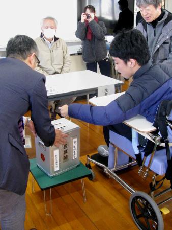 山口県知事選の期日前投票をする県立特別支援学校の生徒（手前右）＝３０日午前、下関市