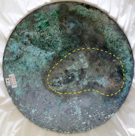 富雄丸山古墳から出土した銅板と痕跡（点線部分）が一致した三角縁神獣鏡（天理大付属天理参考館提供）
