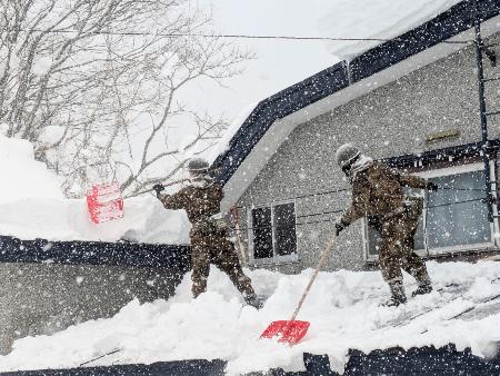 青森県の災害派遣要請を受け、屋根の雪下ろしをする自衛隊員＝２日午後、青森市（陸上自衛隊第９師団提供）
