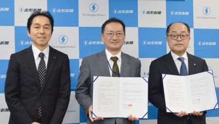 生成ＡＩ開発で協定を結んだ山形新聞社の佐藤秀之社長（右）、新潟日報生成ＡＩ研究所の鶴間尚社長（中央）、新潟日報社の馬場幸夫常務＝２日午後、山形市