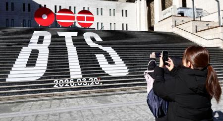 　ソウル中心部の光化門広場周辺でＢＴＳの広告を撮影する観光客＝１月（聯合＝共同）