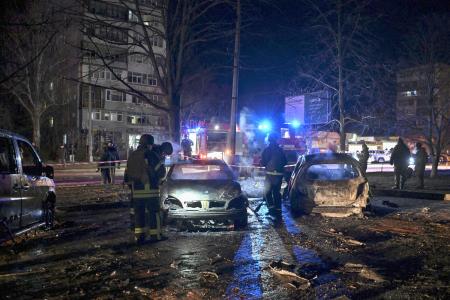 ３日、ウクライナ南部ザポリージャ州で、ロシア軍の攻撃で破壊された車両のそばで活動する消防隊員ら（ロイター＝共同）