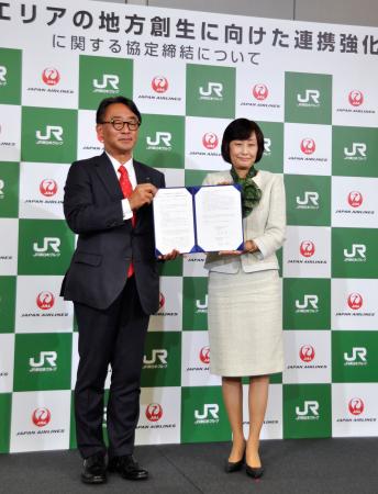 連携協定を結び、撮影に応じるＪＲ東日本の喜勢陽一社長（左）と日航の鳥取三津子社長＝６日午後、東京都港区