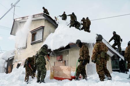 青森市で民家の雪下ろしをする自衛隊員ら＝７日午前