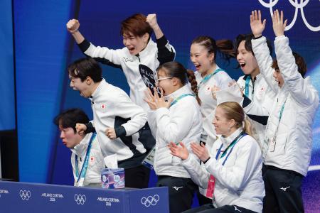 団体男子ＳＰの演技を終え、得点を確認し喜ぶ鍵山優真（左から２人目）＝ミラノ（共同）