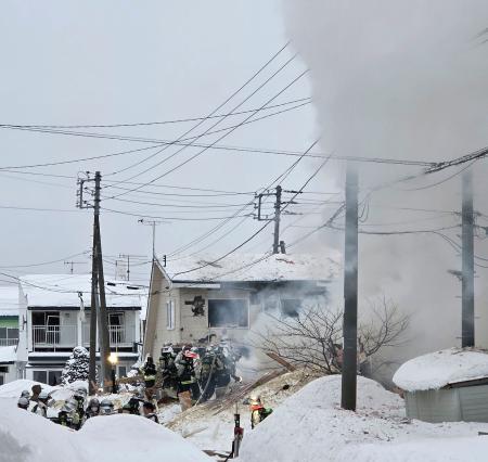 現場付近で消火活動をする消防隊員ら＝９日午前６時５０分、札幌市手稲区