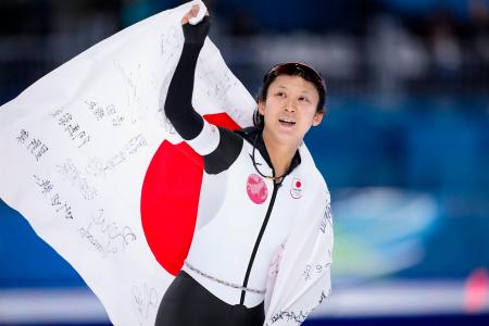 女子1000メートルで銅メダルを獲得し、日の丸を掲げる高木美帆=ミラノ(共同)