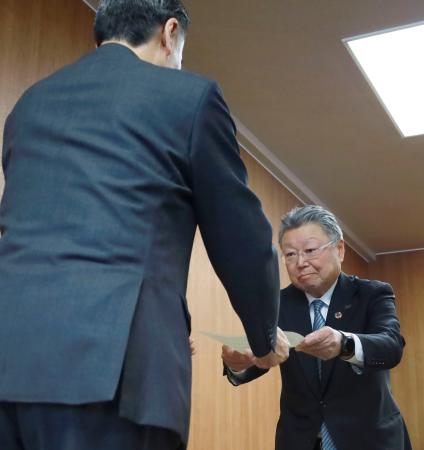 長野県の阿部守一知事（手前）から命令書を受け取る長野県石油商業組合の高見沢秀茂理事長＝１０日午前、県庁