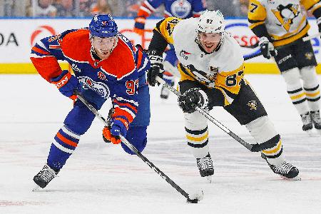 ＮＨＬの試合で競り合うペンギンズのシドニー・クロスビー（右）とオイラーズのコナー・マクデービッド＝１月、エドモントン（イマジンイメージズ・ロイター＝共同）