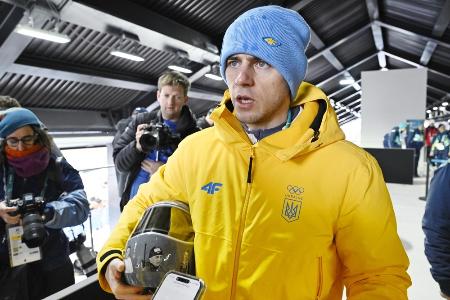 　失格決定を受け、ヘルメットを手に取材に応じるミラノ・コルティナ冬季五輪スケルトン男子ウクライナ代表のウラジスラフ・ヘラスケビッチ＝１２日、イタリア・コルティナダンペッツォ（共同）