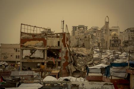 壊滅したガザの市街地と、砂嵐に見舞われた仮設テント＝１３日（ゲッティ＝共同）