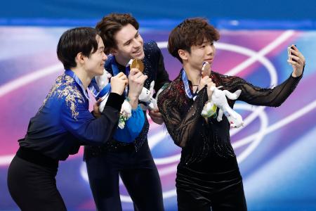 男子の表彰式で記念撮影する（左から）銀メダルの鍵山優真、金メダルのミハイル・シャイドロフ、銅メダルの佐藤駿＝ミラノ（共同）