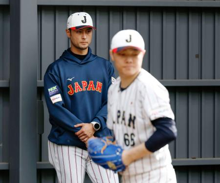 ＷＢＣ日本代表の強化合宿にアドバイザーとして参加し、ブルペンで投球練習を見つめるダルビッシュ。手前は松本＝宮崎