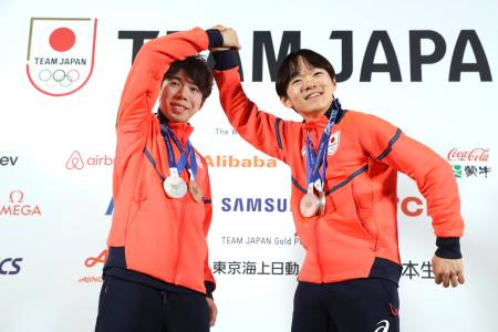 獲得したメダルを胸に撮影に応じるフィギュアスケート男子の鍵山優真（右）と佐藤駿＝１４日、イタリア・ミラノ（共同）