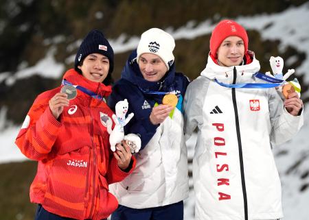 男子個人ラージヒルで銀メダルを獲得し、笑顔の二階堂蓮。中央は優勝したドメン・プレブツ、右は3位のカツペル・トマシャク=プレダッツォ(共同)