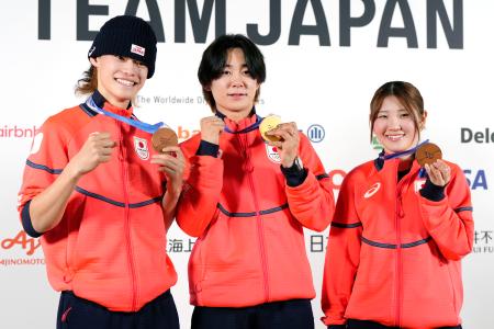 記者会見でメダルを掲げるスノーボード・ハーフパイプの（左から）山田琉聖、戸塚優斗、小野光希＝１５日、イタリア・ミラノ（共同）
