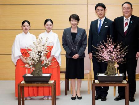 福岡・太宰府天満宮の「梅の使節」から紅白２種類の梅の盆栽を贈られた高市首相（中央）＝１６日午後、首相官邸