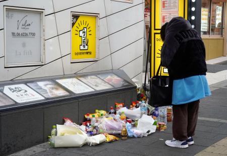 事件があった現場付近で手を合わせる人＝１６日午後、大阪市中央区