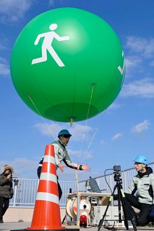 仙台市宮城野区の津波避難タワーから掲げられた避難場所を知らせるバルーン型標識＝１７日午後