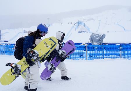 　女子スロープスタイル決勝が悪天候のため延期となり、引き揚げる深田茉莉（左）、岩渕麗楽＝リビーニョ（共同）