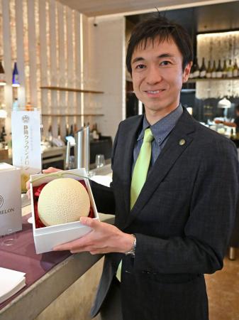商談会で高級メロンの模型を手にする静岡県温室農業協同組合クラウンメロン支所の鈴木陽介経営戦略部長＝１７日、オーストラリア・シドニー（共同）