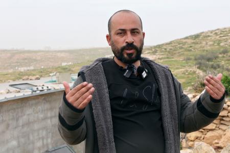 １７日、取材に応じるハムダン・バラール氏＝ヨルダン川西岸南部マサフェルヤッタ（共同）