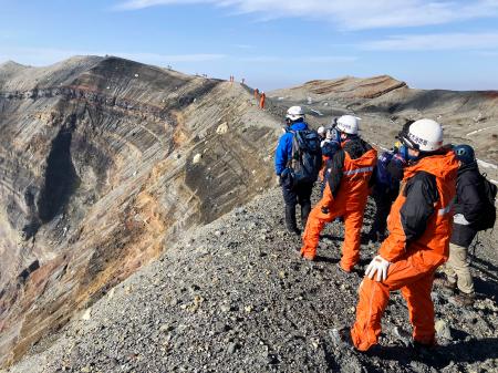 阿蘇中岳火口付近を視察する捜索隊員ら＝１３日、熊本県（同県警提供）