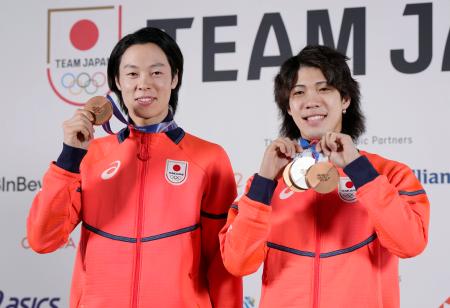 記者会見を終え、メダルを手にポーズをとるノルディックスキー・ジャンプ男子の小林陵侑（左）と二階堂蓮＝１８日、イタリア・ミラノ（共同）