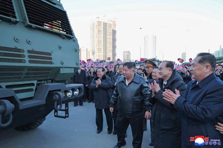 軍需工業部門による超大型放射砲（多連装ロケット砲）の披露式典に臨む北朝鮮の金正恩朝鮮労働党総書記（手前右から３人目）＝１８日、平壌（朝鮮中央通信＝共同）