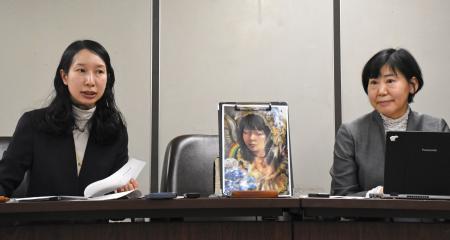 記者会見する原告側の代理人弁護士。中央の絵は原告の自画像＝２０日午後、東京・霞が関の司法記者クラブ