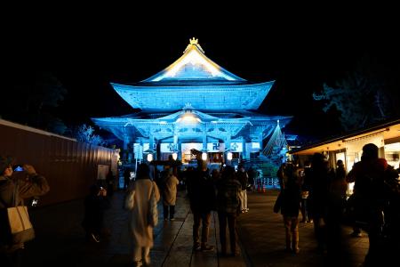地球を表現した「碧色」にライトアップされた善光寺＝２０日夜、長野市